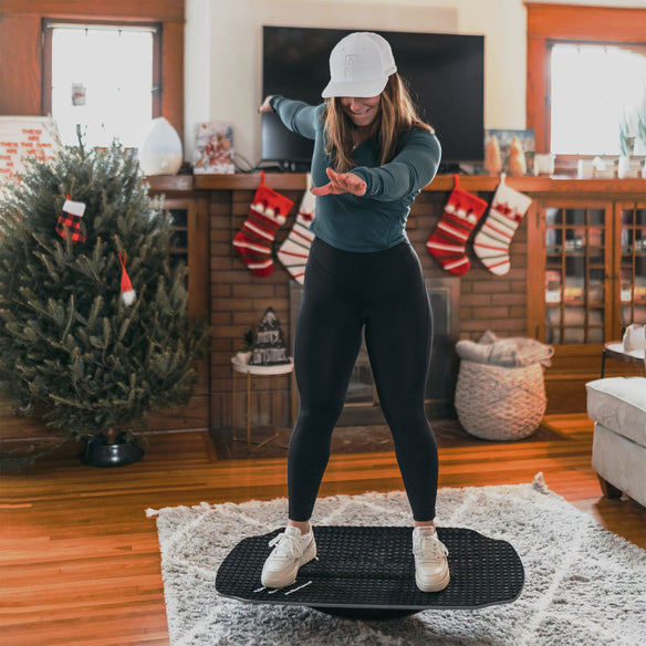 Woman demonstrating how to use the SWELL Wakesurf Tonka Balance Board